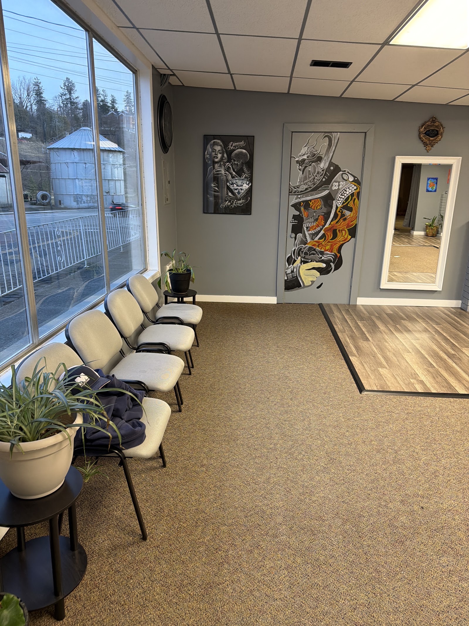 Inside Top Tear Tattoo: the front room with chairs along the windows and framed art on the walls.